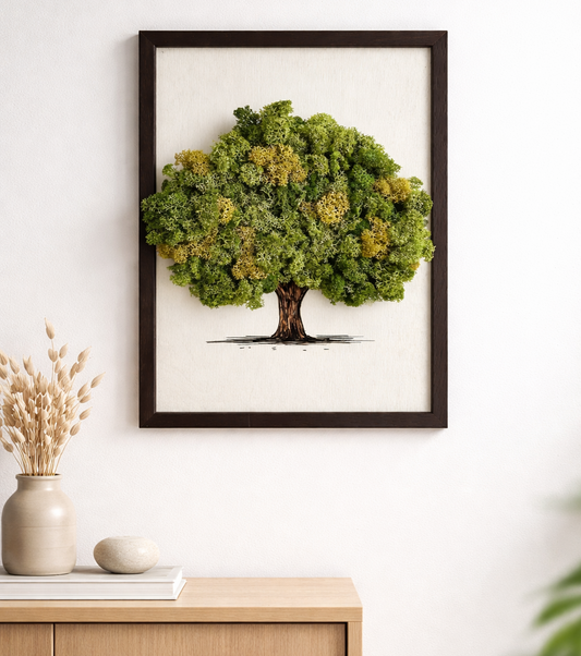 Framed artwork of a tree with green leaves on a white wall above a wooden cabinet.