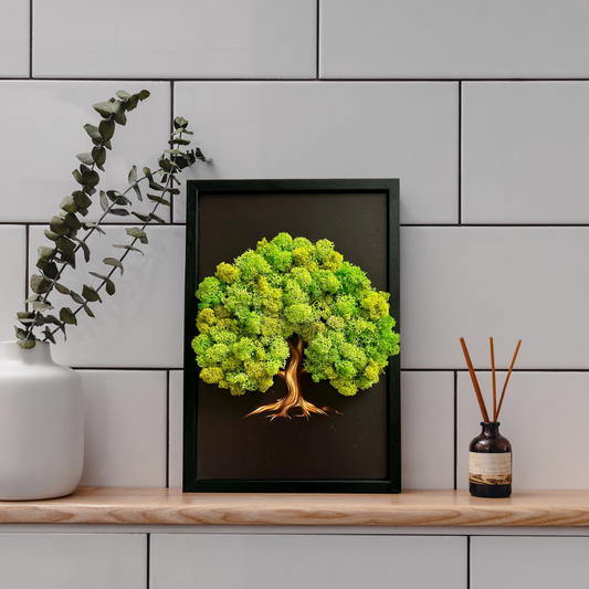 Framed artwork of a green tree on a shelf with decorative items against a tiled wall.