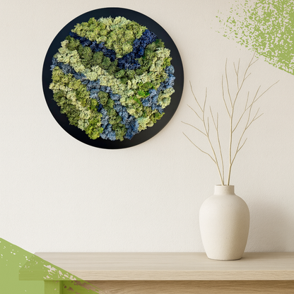 Moss wall art on a white wall with a vase on a shelf below.